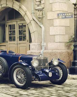 vintage sports car wallpaper featuring a classic blue sports car in an elegant European street setting.