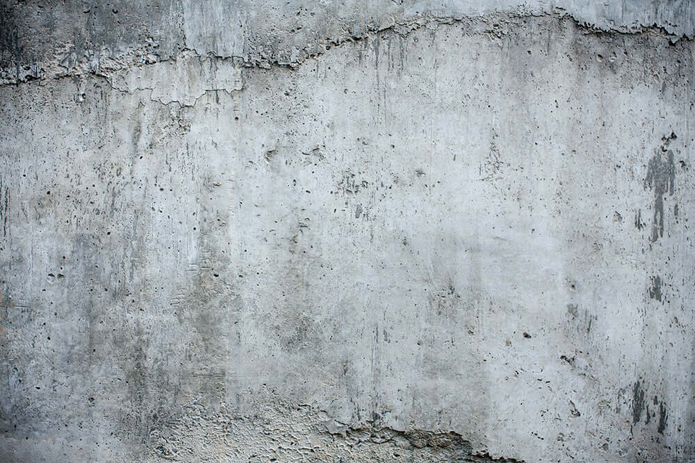 Close-up of a distressed cement wall, perfect for retro industrial cement wallpaper designs.