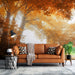 Golden Autumn Forest Wallpaper Mural | Sunlit Woodland Escape | Warm Yellow Botanical Décor - cozy living room scene with orange leather sofa, autumn foliage wall backdrop