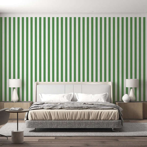 Green and white vertical striped wallpaper | Living room and bedroom decorative wall — bold green white stripes behind a modern white upholstered bed with neutral bedding and minimalist bedside tables