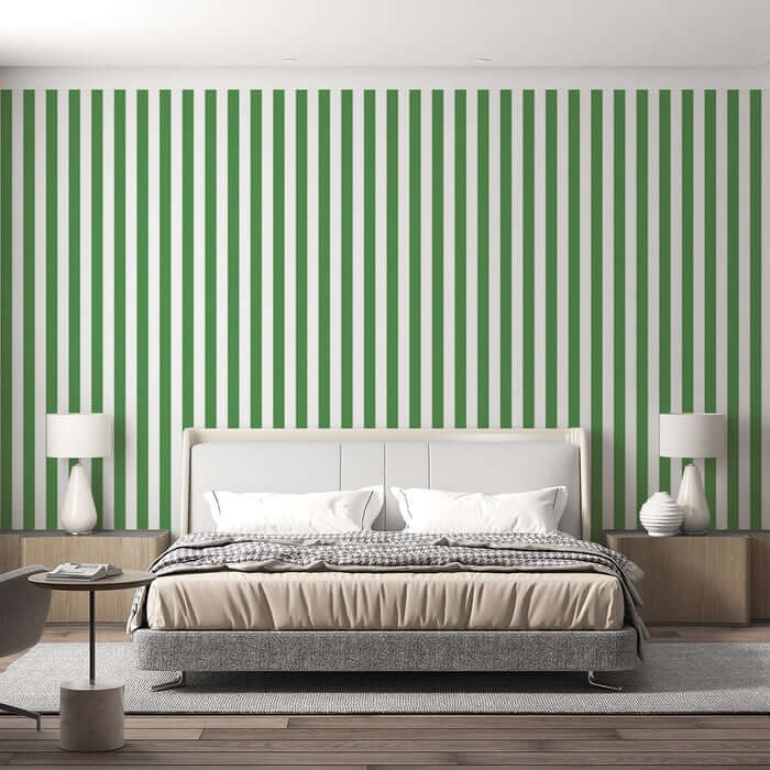 Green and white vertical striped wallpaper | Living room and bedroom decorative wall — bold green white stripes behind a modern white upholstered bed with neutral bedding and minimalist bedside tables