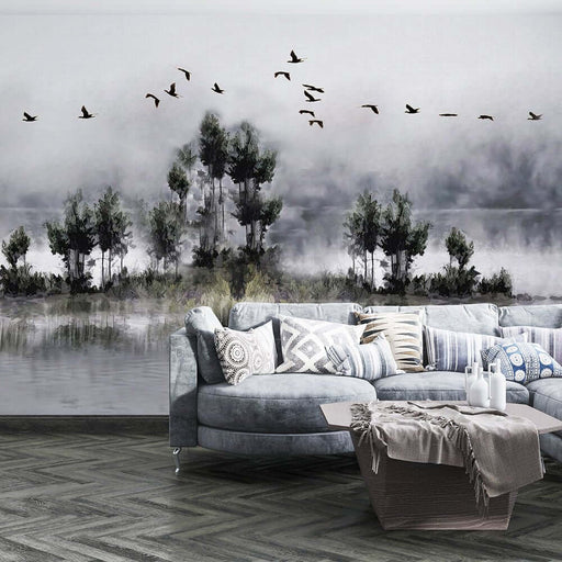 Ink Wash Landscape Wallpaper Mural | Flying Birds & Reflections | Tranquil Eastern Ambiance: serene Chinese ink wash scene with mountains, flying birds, and a misty lakeside backdrop behind a modern living room.