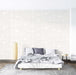 Minimalist white relief wallpaper | 3D geometric mural: a serene bedroom featuring a white bed against a wall with geometric relief patterns in white