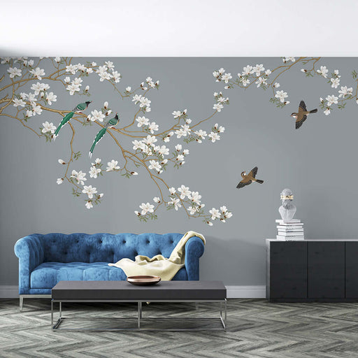 New Chinese Flower and Bird Wallpaper Mural | Magnolia Flower and Bird: serene living room with blue tufted sofa, white magnolia blossoms on branches, and birds against a muted wall