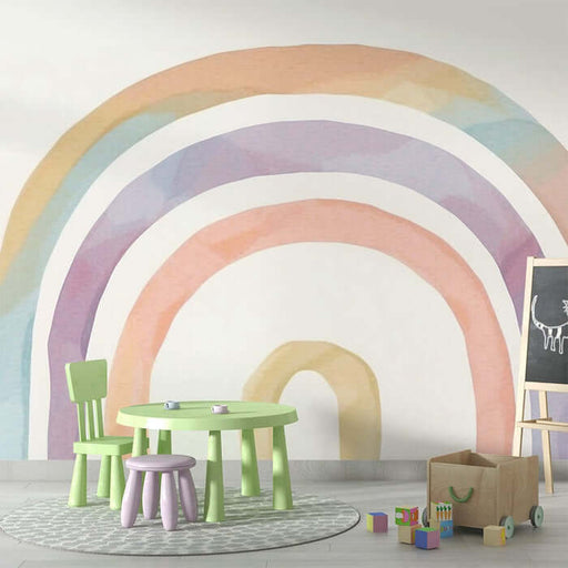 Rainbow watercolor wallpaper mural | Living room and bedroom decorative wall: Gentle Morandi rainbow mural with pastel arches in a kids' play area, featuring green table and purple stools