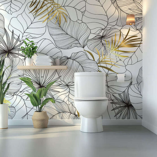Tropical leaf wallpaper mural | Living room bedroom decorative wall in a luxe bathroom scene showing foliage wallpaper with gold accents and modern toilet
