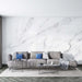 White Marble Textured Wallpaper Mural - Natural Stone Effect in a modern living room with grey sectional, blue cushions, and minimalist coffee tables
